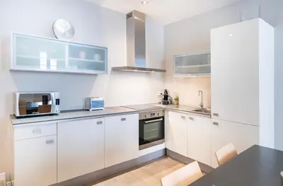 a kitchen with white cabinets and a black counter top at Appartement Cannes, Majestic in Cannes