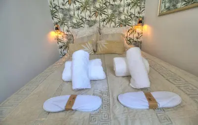 a bed with white pillows and towels on it at Cannes centre rue d'antibes et palais in Cannes