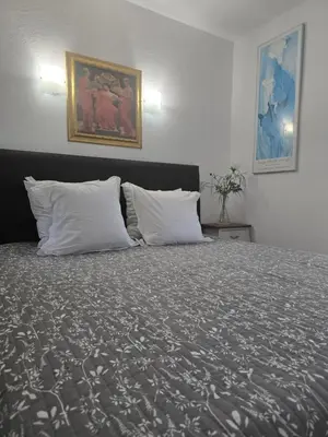 a bedroom with a large bed with white pillows at 1-Bedroom guesthouse with pool access in Cannes