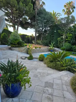 a garden with a swimming pool and some plants at 1-Bedroom guesthouse with pool access in Cannes