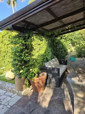 a patio with a couch under a pergola at 1-Bedroom guesthouse with pool access in Cannes