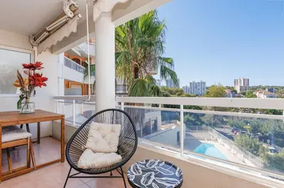 a dining room with a table and a large window at Appartement Grand Balcon Sud avec Piscine proche Cannes in Le Cannet