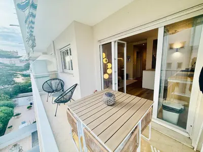 a balcony with a wooden table and chairs at B020- Elegante et lumineux a deux pas plages et centre in Cannes