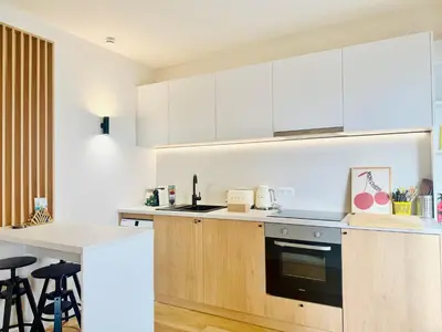 a kitchen with white cabinets and a counter top at B020- Elegante et lumineux a deux pas plages et centre in Cannes