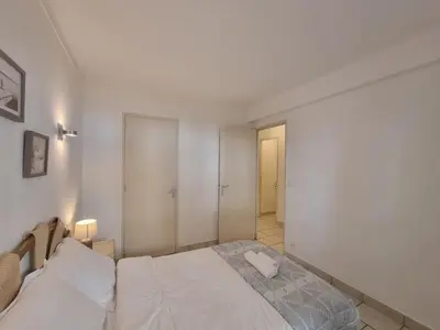 a bedroom with a bed with a phone on it at Ferrié Plage Palais Cannes in Cannes