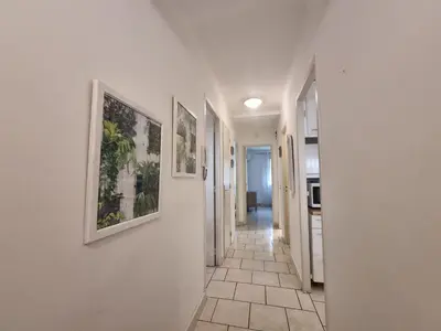 a hallway with pictures on the walls of a house at Ferrié Plage Palais Cannes in Cannes