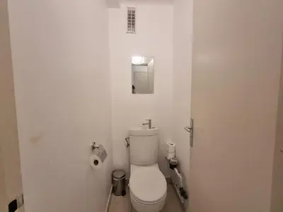 a white bathroom with a toilet in a room at Ferrié Plage Palais Cannes in Cannes