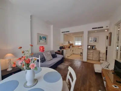 a living room with a blue couch and a table at Ferrié Plage Palais Cannes in Cannes