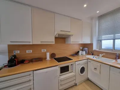 a kitchen with white cabinets and a sink at Ferrié Plage Palais Cannes in Cannes