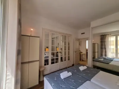 a bedroom with two beds and a large mirror at Ferrié Plage Palais Cannes in Cannes
