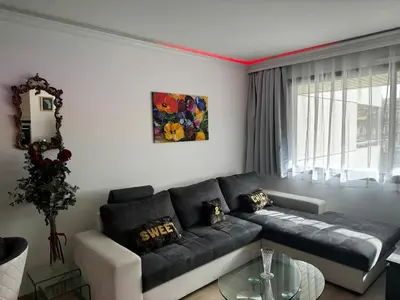 a living room with a black couch and a table at Gray D'albion Cannes centre , 1 min des plages in Cannes