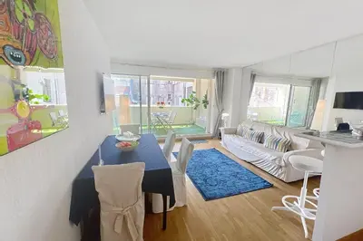 a living room with a blue table and a couch at Cannes central Rue d'Antibes wide 1 BDR w terrace - quiet in green scenery in Cannes