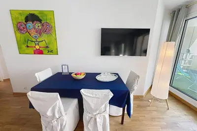 a dining room with a blue table and chairs at Cannes central Rue d'Antibes wide 1 BDR w terrace - quiet in green scenery in Cannes