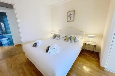a bedroom with a white bed with two towels on it at Cannes central Rue d'Antibes wide 1 BDR w terrace - quiet in green scenery in Cannes