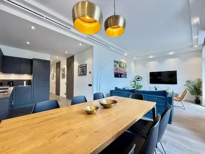 a dining room with a wooden table and blue chairs at Carré d'Or - Luxueux - Vue mer in Cannes