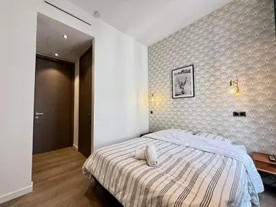 a bedroom with a large bed with a striped blanket at Carré d'Or - Luxueux - Vue mer in Cannes