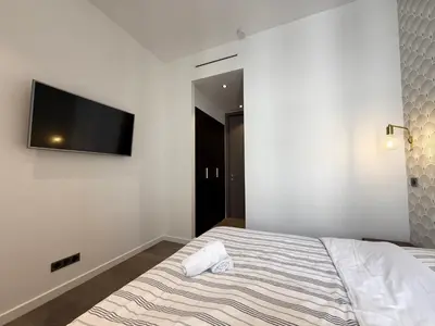 a bedroom with a bed and a flat screen tv on the wall at Carré d'Or - Luxueux - Vue mer in Cannes