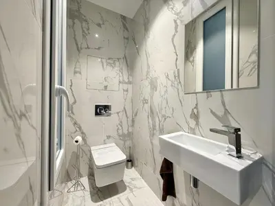 a white bathroom with a sink and a toilet at Carré d'Or - Luxueux - Vue mer in Cannes