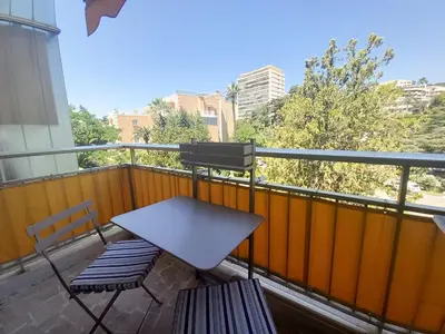 a balcony with a table and a bench on a balcony at Trident G in Cannes
