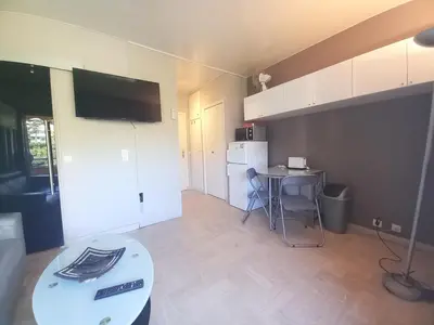a living room with a table and a kitchen at Trident G in Cannes