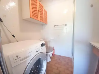 a washing machine in a bathroom with a toilet at Trident G in Cannes