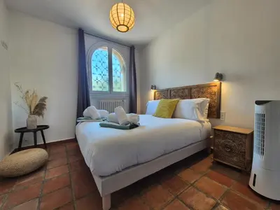 a bedroom with a bed with a laptop on it at Villa Lou San Peyre in Le Cannet