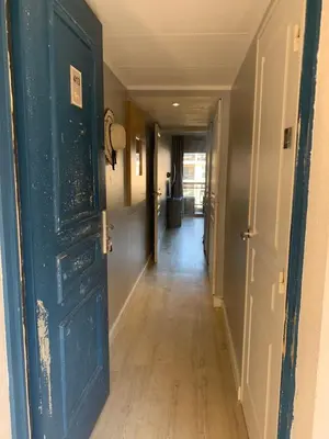 an empty hallway with an open door and a hallwayngth at 2 pièces vue piscine et plage à 2min in Cannes