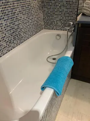 a blue towel sitting on the side of a bath tub at 2 pièces vue piscine et plage à 2min in Cannes
