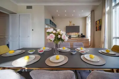a dining room table with a vase of oranges on it at Belétage - 5BDR - 4 Bath - Cannes Center - Garage and AC in Cannes