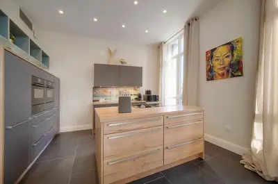 a kitchen with a large wooden island in a room at Belétage - 5BDR - 4 Bath - Cannes Center - Garage and AC in Cannes