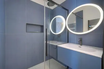 a blue bathroom with a sink and a mirror at Belétage - 5BDR - 4 Bath - Cannes Center - Garage and AC in Cannes