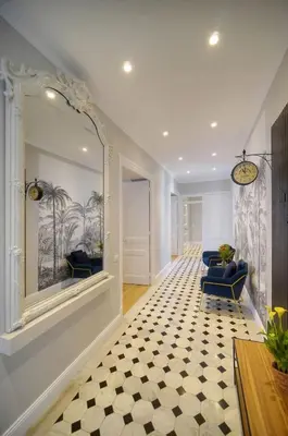 a hallway with two blue chairs and a mirror at Belétage - 5BDR - 4 Bath - Cannes Center - Garage and AC in Cannes