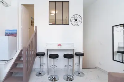 a kitchen with a counter and stools in a room at Modern 2 Rooms in the heart of Cannes in Cannes