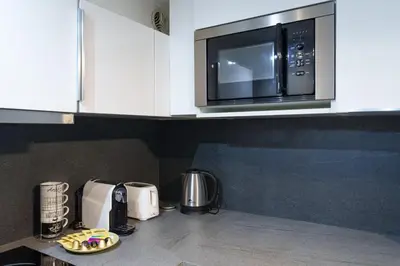 a kitchen with a microwave oven and a counter top at Modern 2 Rooms in the heart of Cannes in Cannes