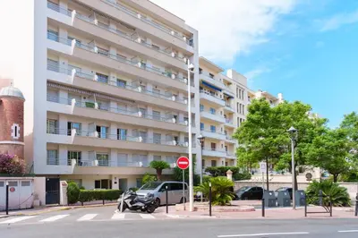 a large apartment building with a motorcycle parked in front of it at Modern 2 Rooms in the heart of Cannes in Cannes
