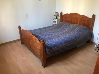 a bed with a wooden frame in a bedroom at Villa cannoise en bord de mer in Cannes