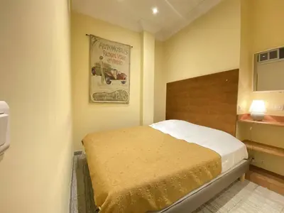 a bedroom with a bed and a poster on the wall at Cannes La Croisette - Studio face mer avec chambre cabine et balcon in Cannes