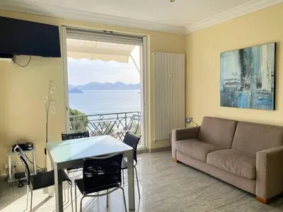 a living room with a couch and a view of the ocean at Cannes La Croisette - Studio face mer avec chambre cabine et balcon in Cannes