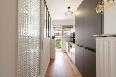 a kitchen with a hallway with a refrigerator and a door at 1-Br with Terrace Palm Beach Close to Beaches in Cannes
