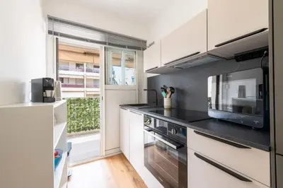 a kitchen with white cabinets and a black counter top at 1-Br with Terrace Palm Beach Close to Beaches in Cannes