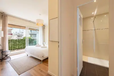 a bedroom with a bed and a large window at 1-Br with Terrace Palm Beach Close to Beaches in Cannes