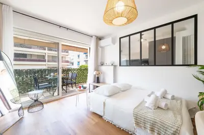 a bedroom with a white bed and a large window at 1-Br with Terrace Palm Beach Close to Beaches in Cannes