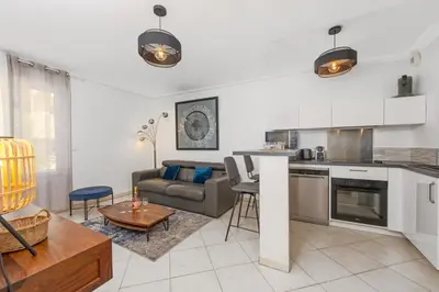 a kitchen and living room with a couch and a table at Joli deux pièces - Quartier Pointe Croisette - EC in Cannes