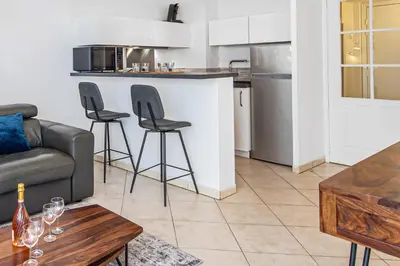 a living room with a couch and a kitchen at Joli deux pièces - Quartier Pointe Croisette - EC in Cannes