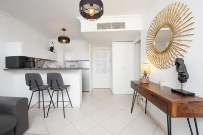 a living room with a table and chairs and a mirror at Joli deux pièces - Quartier Pointe Croisette - EC in Cannes