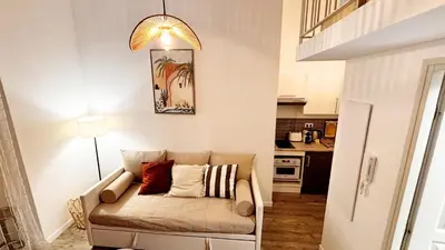 a living room with a couch and a lamp at Proche Palais Des Festivals, T2 avec Mezzanine - Palmazur Vacances in Cannes