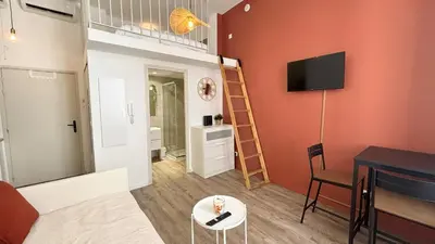 a living room with a loft bed and a table at Proche Palais Des Festivals, T2 avec Mezzanine - Palmazur Vacances in Cannes