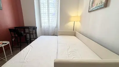 a white bed in a small room with a table at Proche Palais Des Festivals, T2 avec Mezzanine - Palmazur Vacances in Cannes