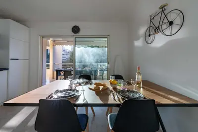 a dining room with a table and a bike on the wall at 2-Br Apartment Residence with Pool Near La Croisette in Cannes
