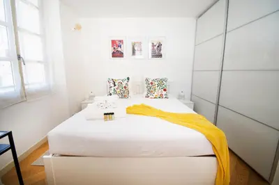 a bedroom with a white bed with an orange blanket on it at Princess Victoria Standing Presta in Cannes